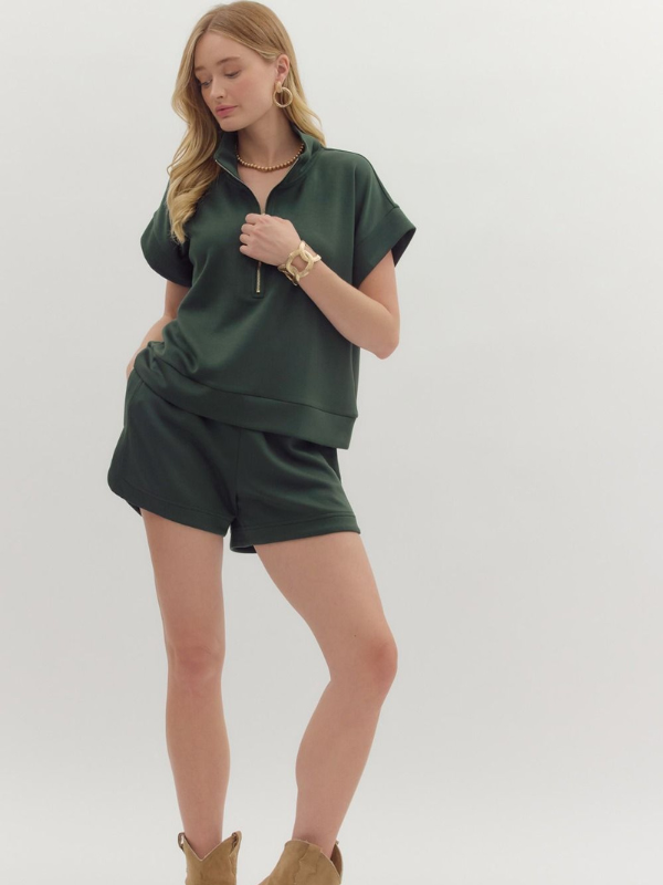 Woman wearing a green outfit with a plain background