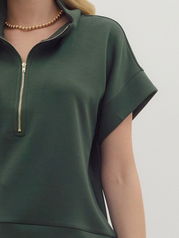Green short-sleeve top with a zipper on a plain background