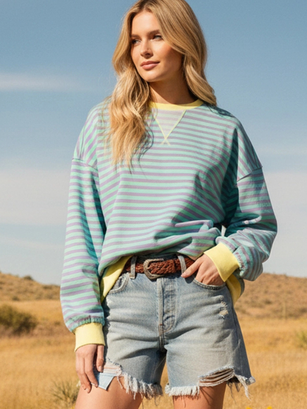 Woman wearing a striped sweater and denim shorts in a desert setting