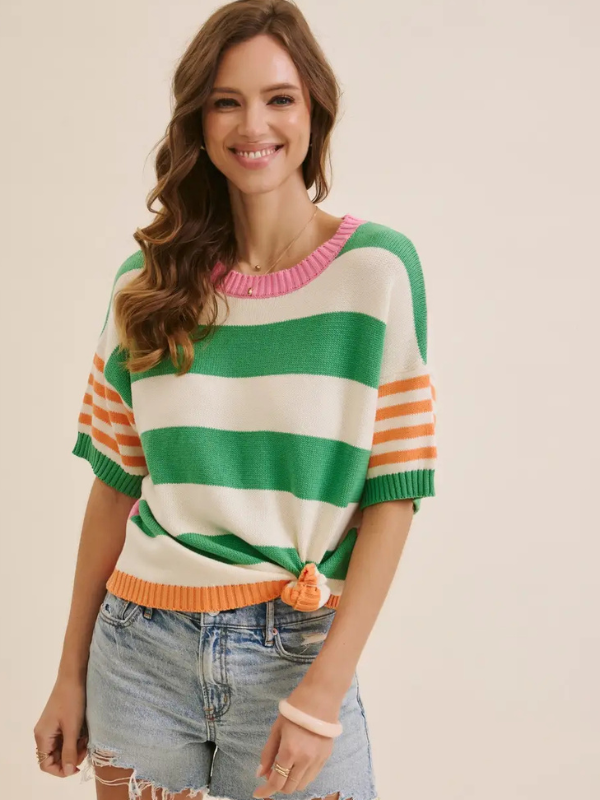 Woman wearing a colorful striped sweater with a plain background