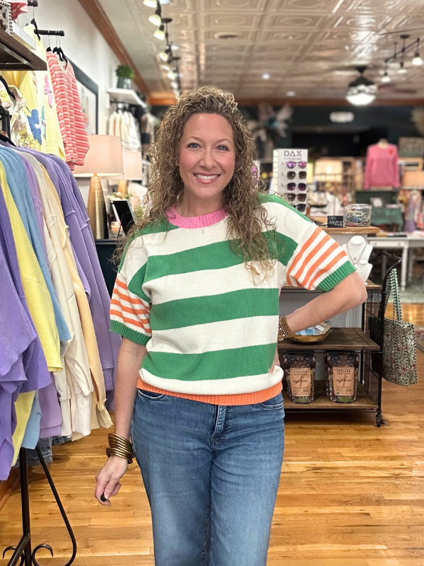 Woman wearing a colorful striped sweater in a clothing store