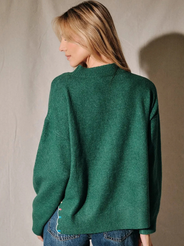 woman wearing a green peace and joy sweater 