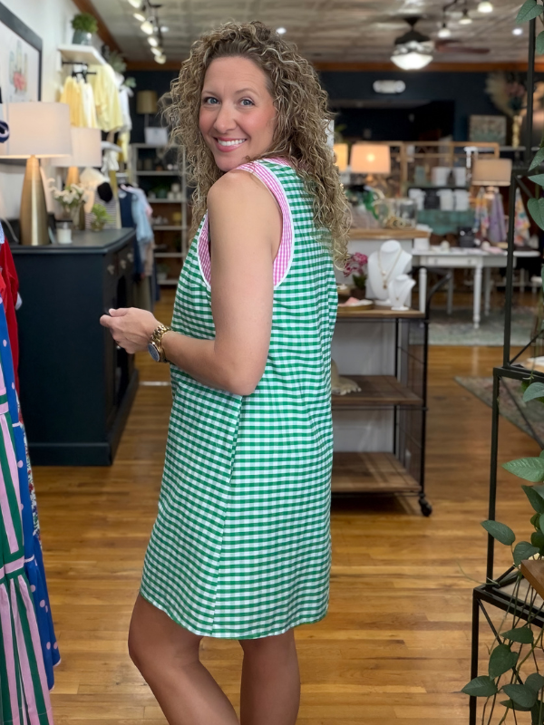 Woman wearing a green checkered dress in a store setting