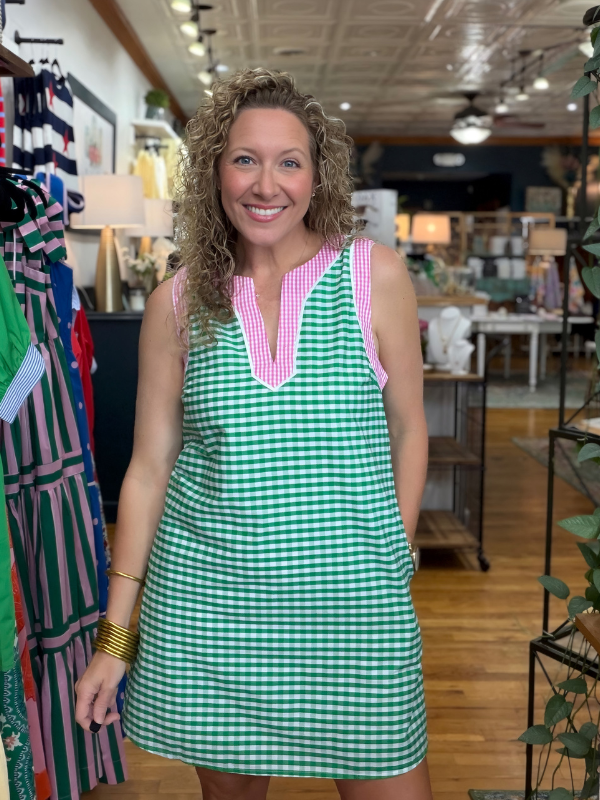 Woman wearing a green checkered dress with pink accents in a store setting