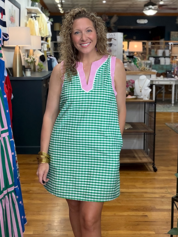 Woman wearing a green checkered dress with pink trim in a store setting