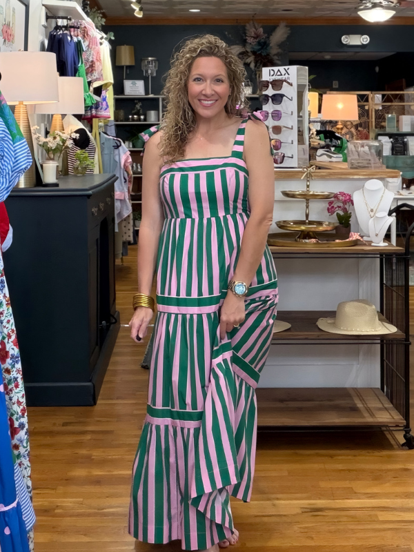 Woman in a green and pink striped dress standing in a store.