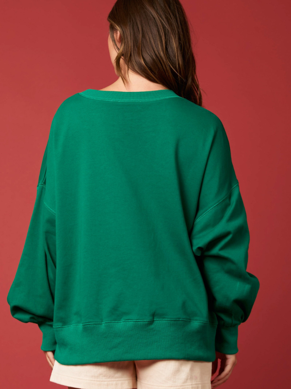 Person wearing a green sweatshirt against a red background