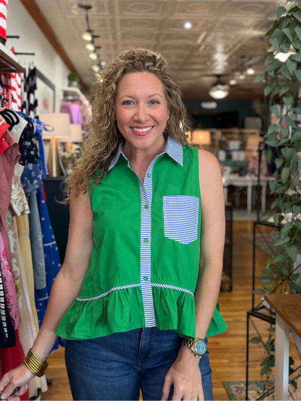 Woman wearing a green sleeveless blouse with a striped pattern in a store setting