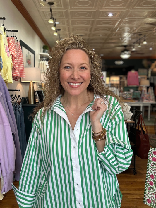 Woman wearing a green and white striped shirt in a store setting