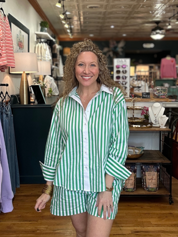 Woman wearing a green and white striped outfit in a store setting