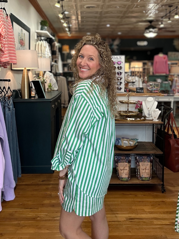 Woman in a green and white striped dress standing in a store.