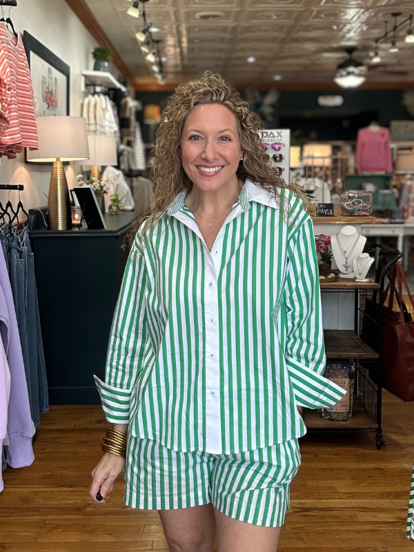 Woman wearing green and white striped pajama set in a store setting
