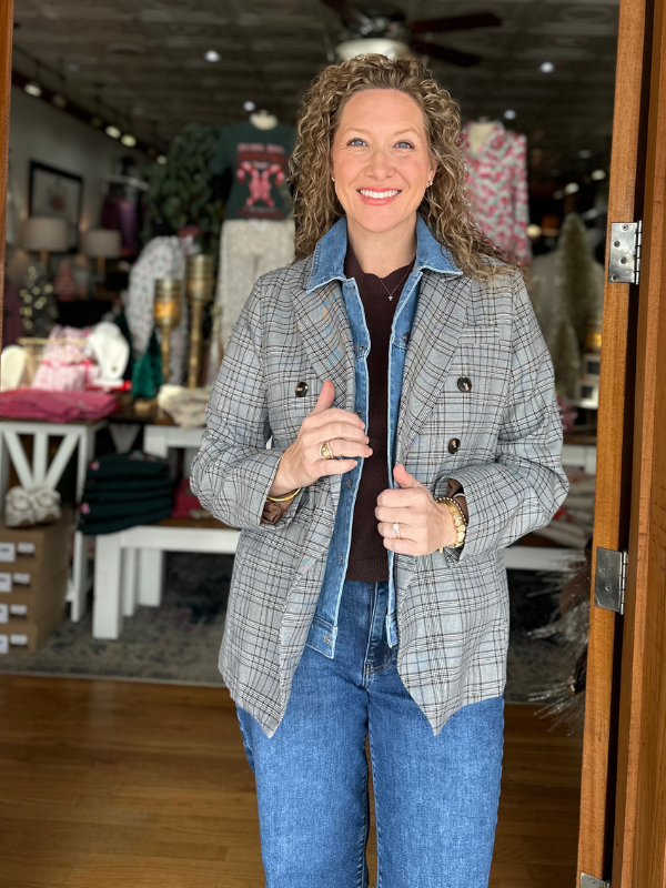 Woman wearing a plaid jacket and blue jeans in a store setting