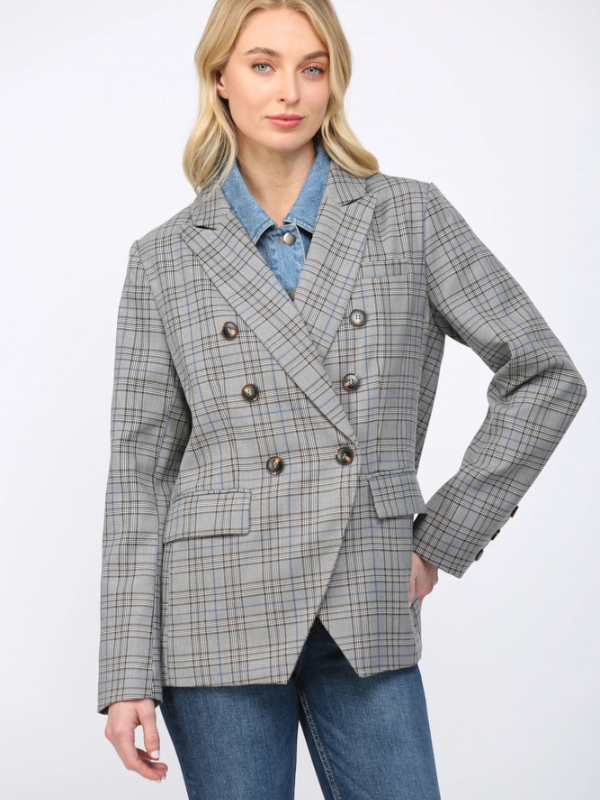 Woman wearing a gray checkered blazer over a blue shirt on a white background