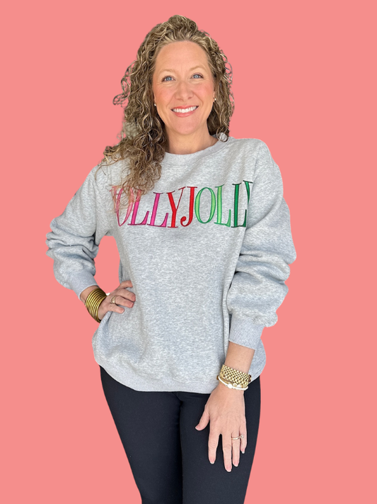 Woman wearing a gray sweatshirt with colorful text on a pink background