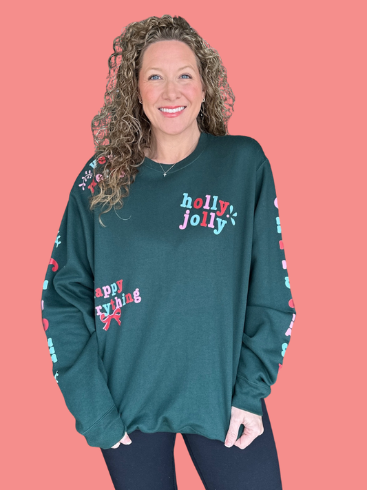 Woman wearing a teal sweatshirt with 'holly jolly' and 'happy railing' text on a pink background