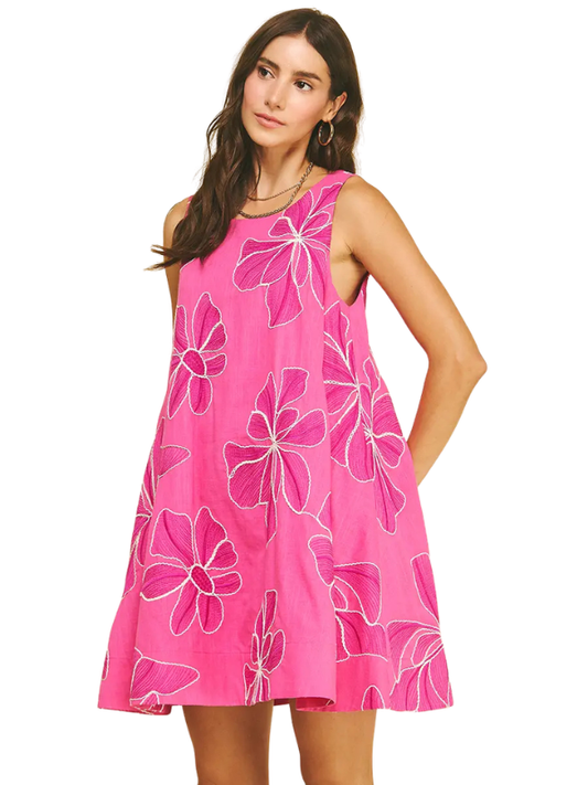 Woman wearing a pink dress with floral patterns on a white background