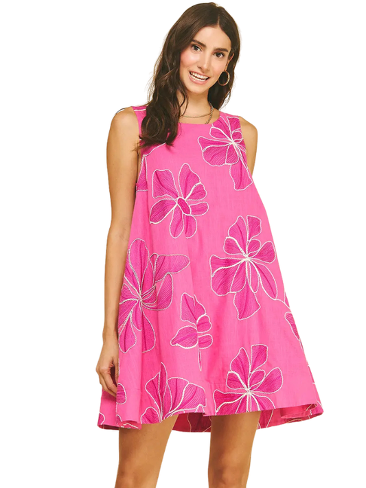 Woman wearing a pink dress with floral patterns on a white background