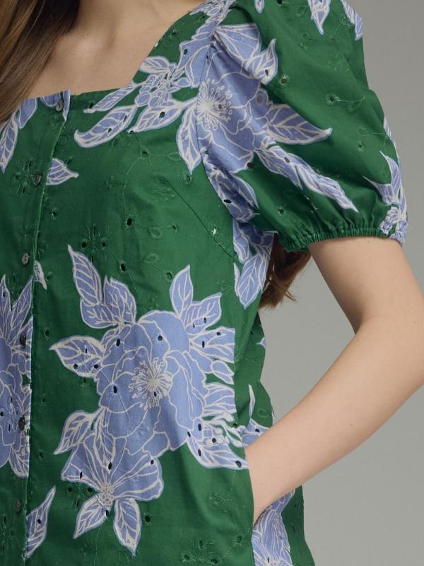 Green dress with blue floral patterns on a gray background