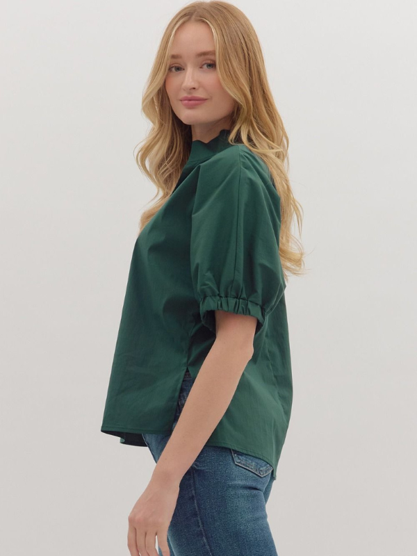 Woman wearing a green blouse and blue jeans on a white background