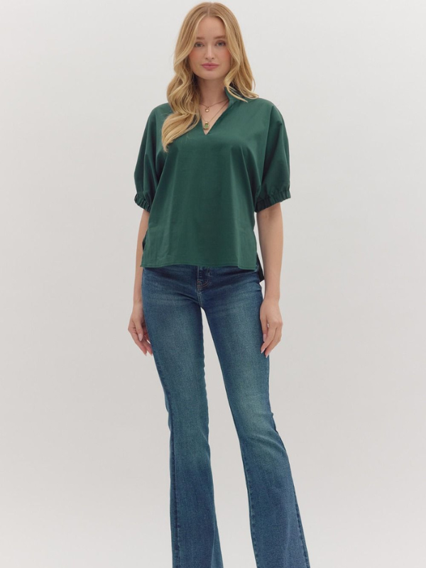 Woman wearing a green blouse and blue jeans on a white background