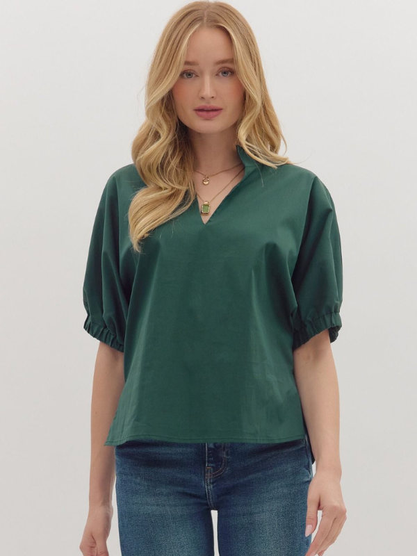 Woman wearing a green blouse and blue jeans on a white background