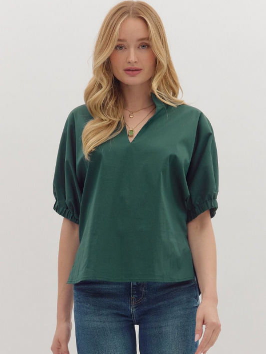 Woman wearing a green blouse and blue jeans on a white background