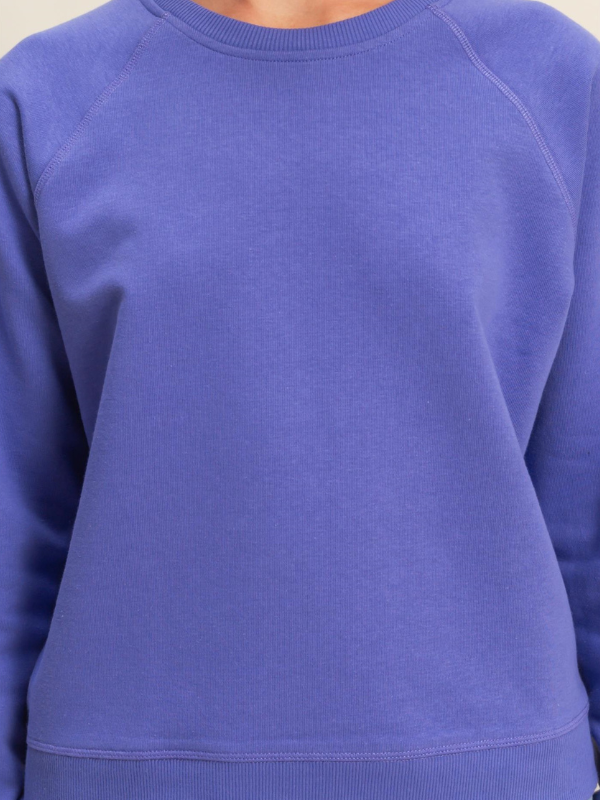 Close-up of a blue sweatshirt with a plain background