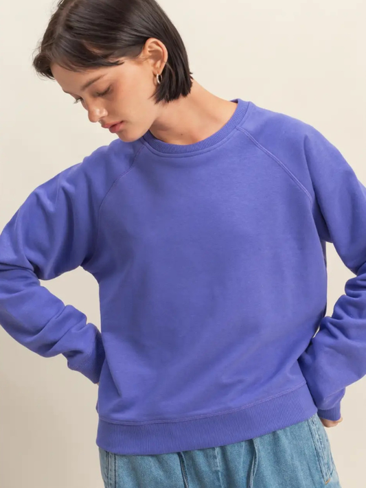 Person wearing a blue sweatshirt against a beige background