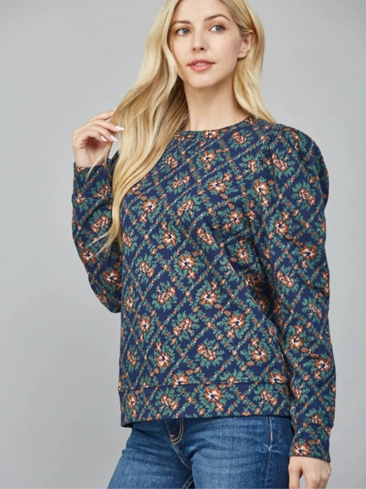 Woman wearing a blue patterned sweater against a gray background