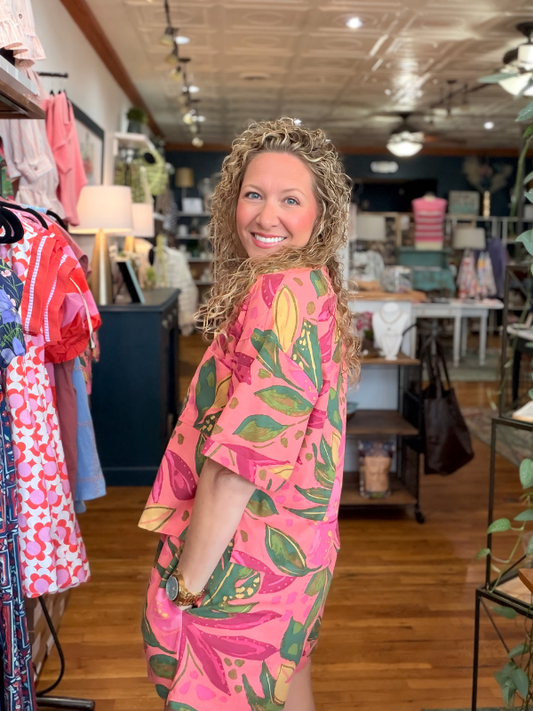 Woman wearing a pink floral dress in a clothing store
