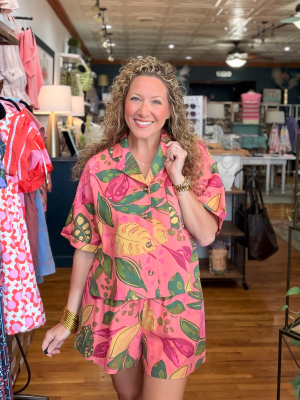 Woman wearing a pink floral outfit in a store setting