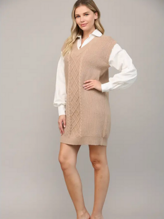 Woman wearing a beige knitted vest over a white shirt on a gray background