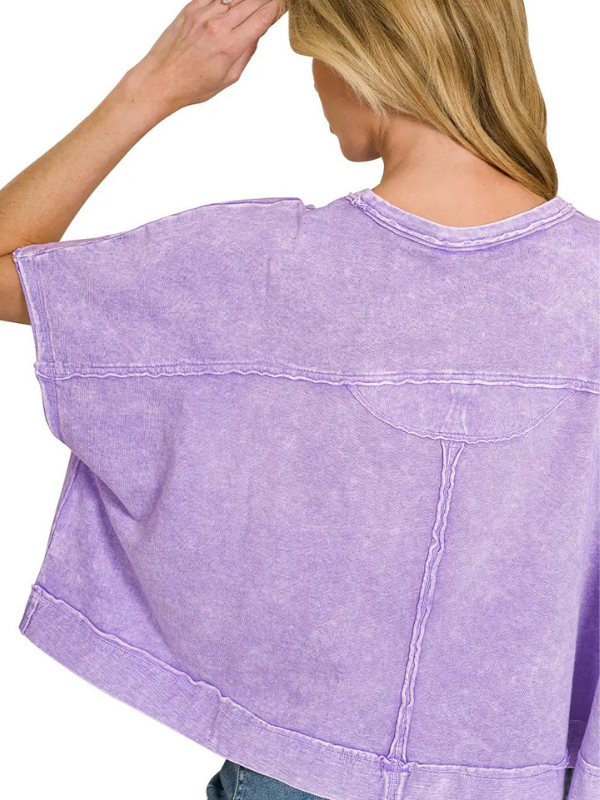 A woman shown from the back wearing a lavender-purple cropped t-shirt with a mineral-wash finish and a single chest pocket.