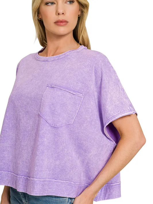 A woman wearing a lavender purple short-sleeve crewneck t-shirt with a chest pocket, shown against a plain white background.