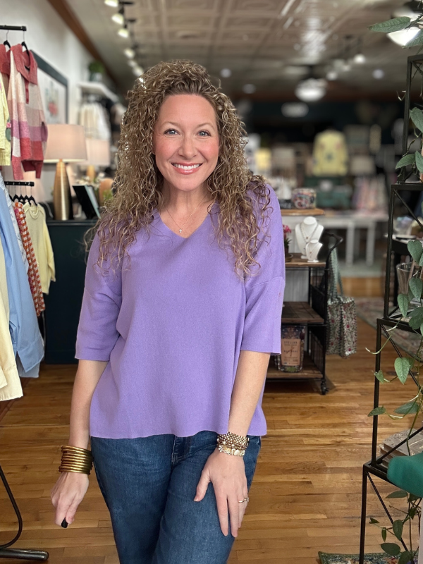 Woman wearing a purple shirt in a store setting