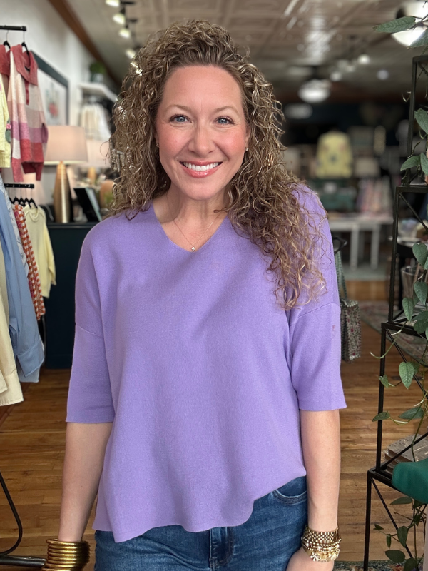 Woman wearing a purple shirt in a store setting