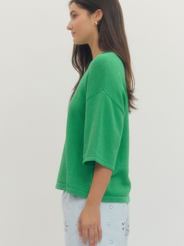 Person wearing a green top and light blue pants on a white background