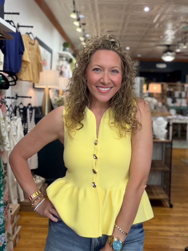 Woman wearing a yellow top in a store setting
