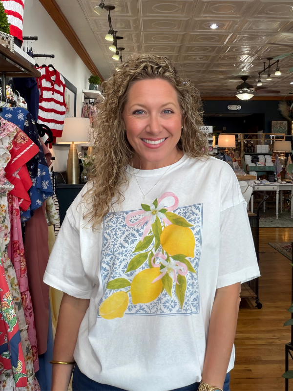 Woman wearing a white t-shirt with a lemon design in a store setting
