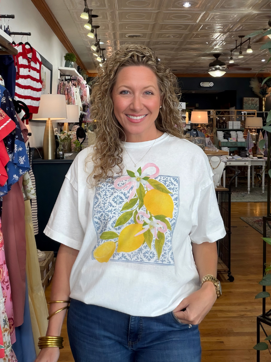 Woman wearing a white t-shirt with a lemon design in a store setting
