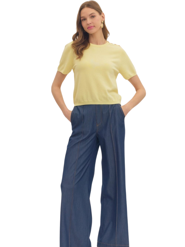 Woman wearing a yellow top and blue pants on a white background