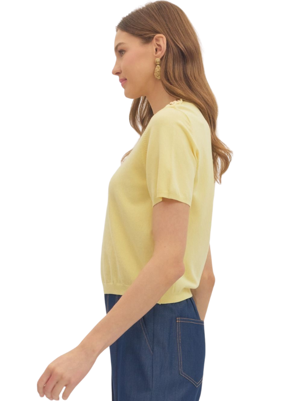 Woman wearing a yellow top and blue jeans on a white background