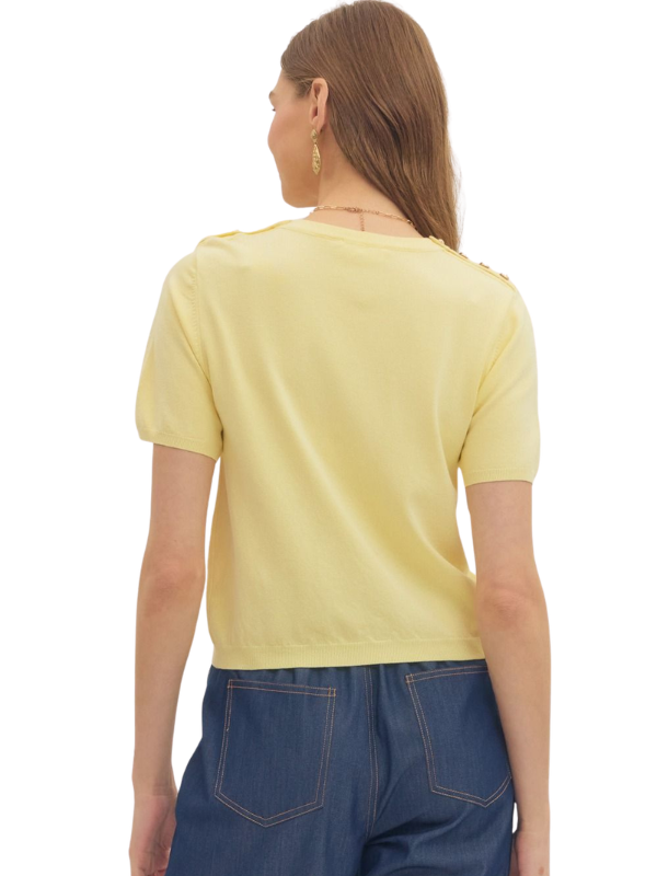 Woman wearing a yellow top and blue pants on a white background