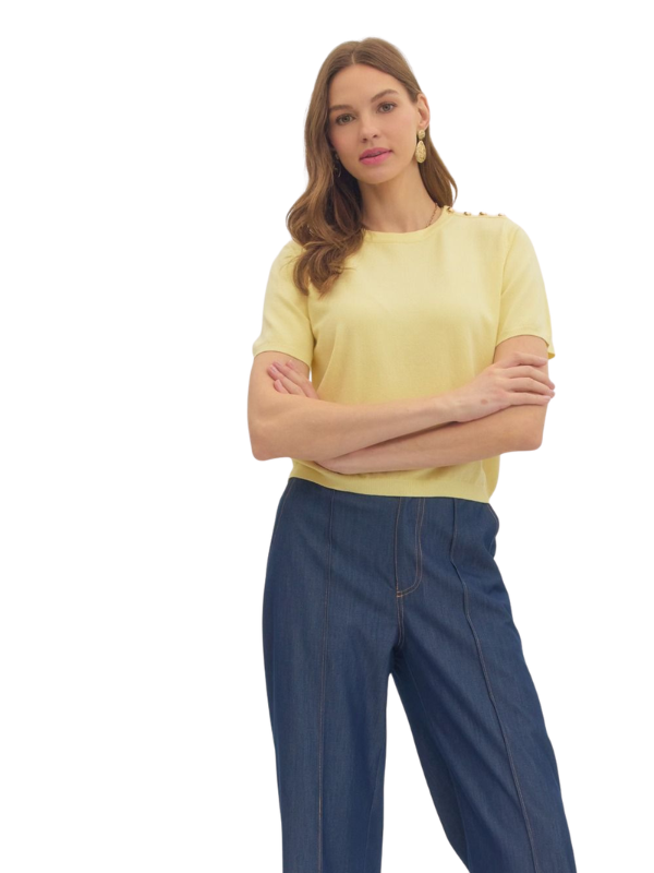 Woman wearing a yellow top and blue pants on a white background