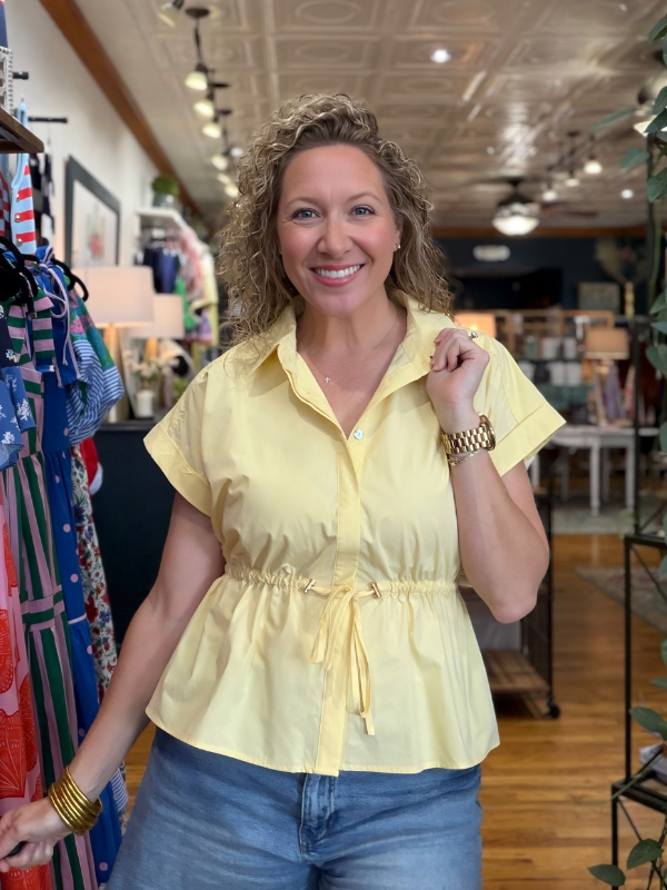 Woman wearing a yellow blouse in a store setting