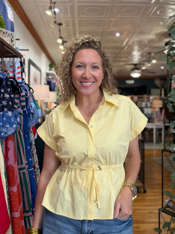 Woman wearing a yellow blouse in a store setting
