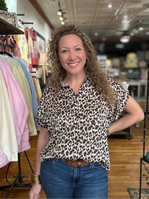 Woman wearing a leopard print shirt in a clothing store