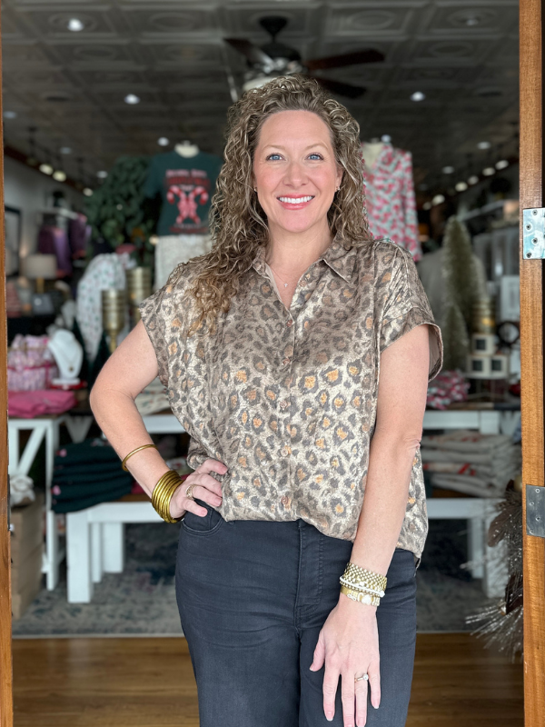 Woman standing in a store with various items in the background