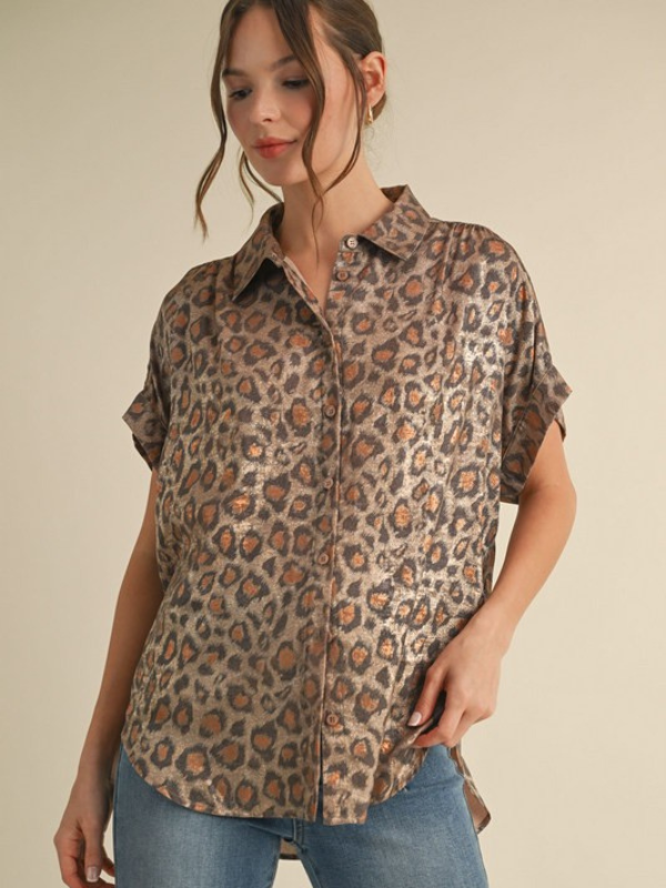Woman wearing a leopard print shirt and jeans on a beige background